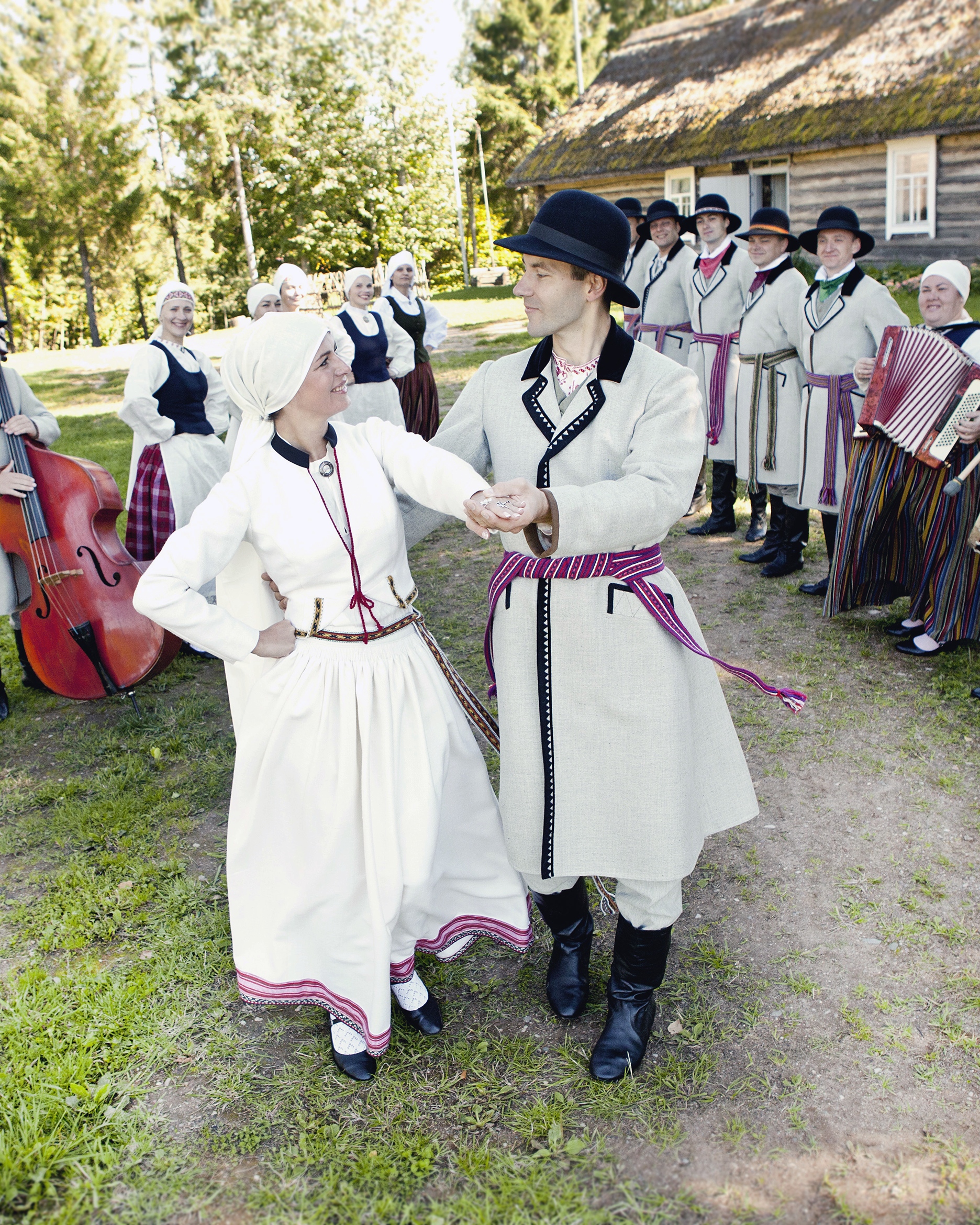The wedding couple dances in traditional Latvian costumes