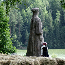 Small seto girl next to big women statue. Both are looking to the lake.
